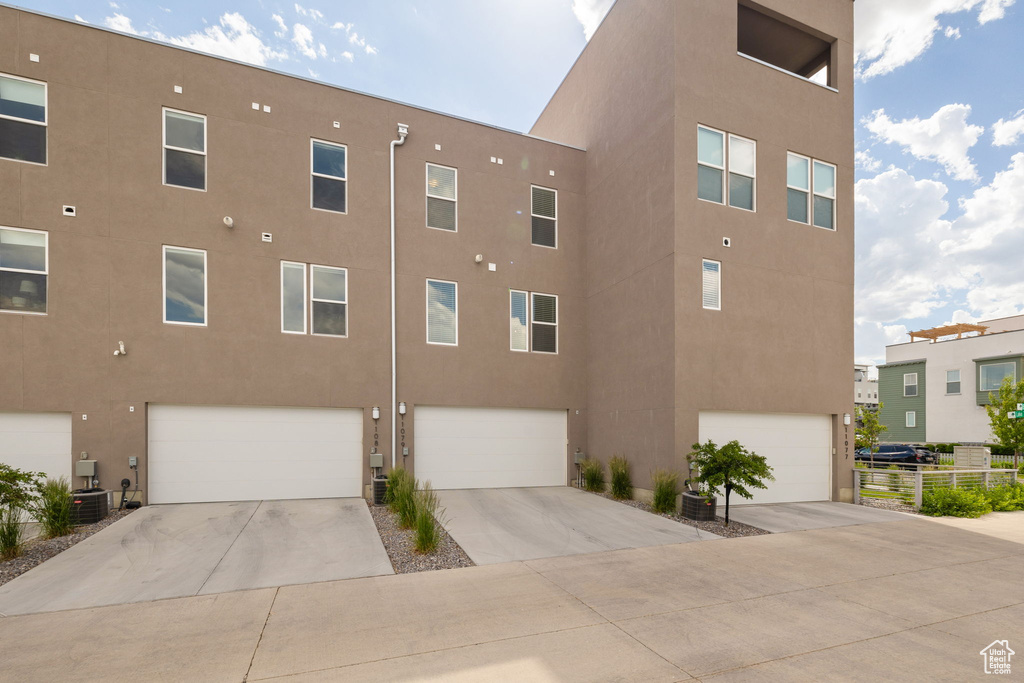 View of property featuring an attached garage and concrete driveway