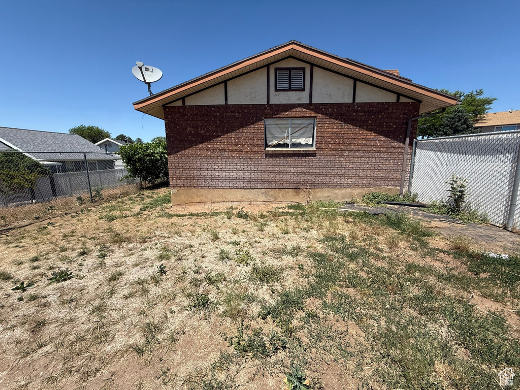 View of side of property featuring brick siding and stucco siding