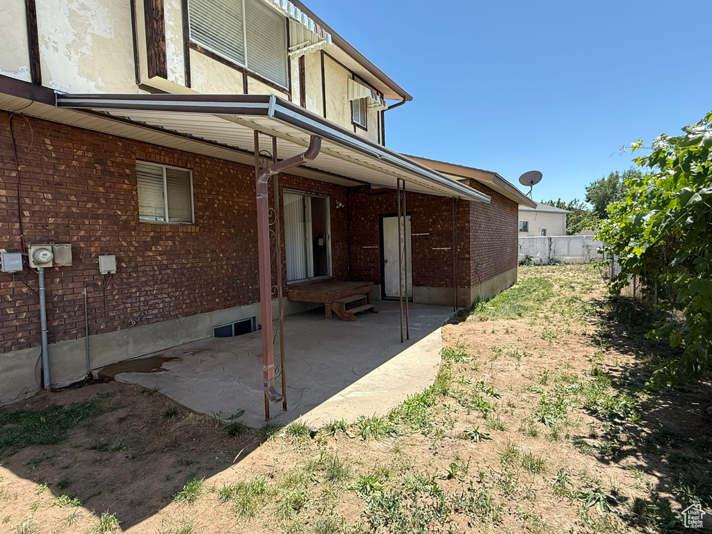 Rear view of property with a patio and brick siding