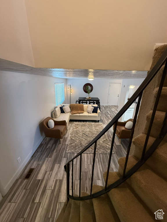 Living area featuring wood finished floors, stairway, and baseboards
