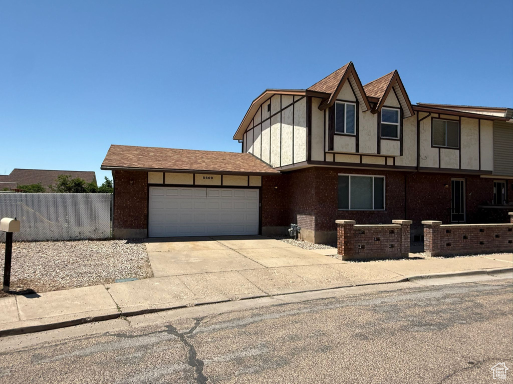 English style home with an attached garage and concrete driveway
