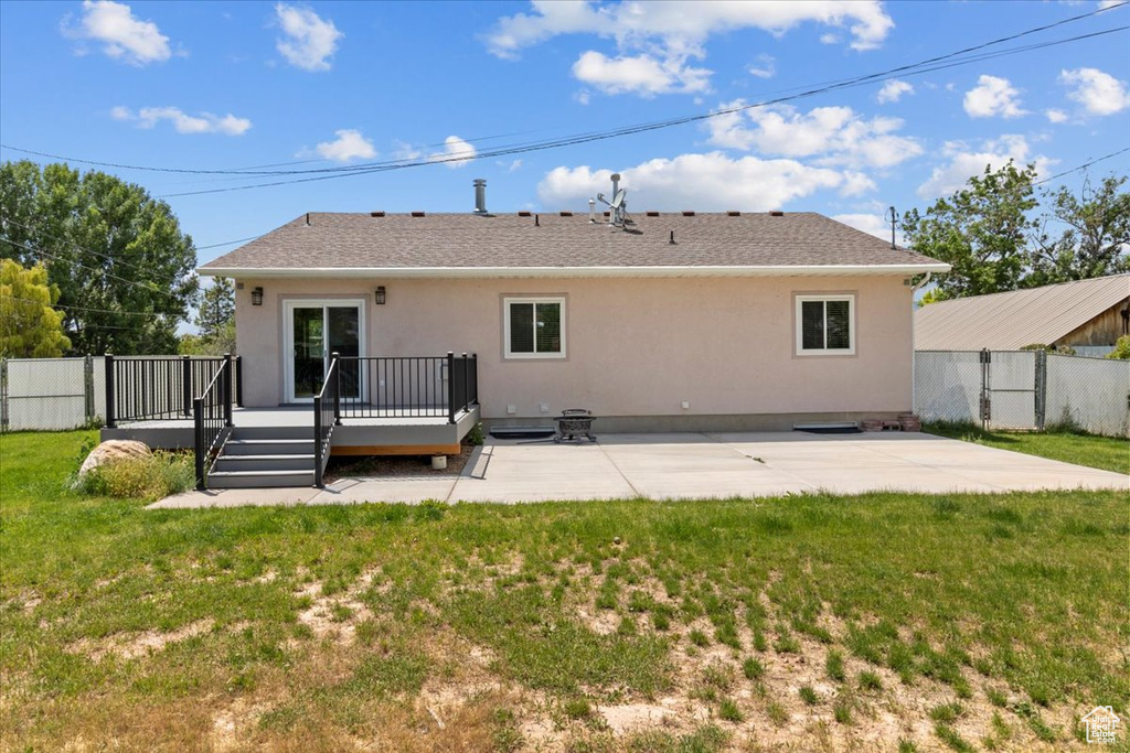 Rear view of house featuring a patio area, stucco siding, and a deck