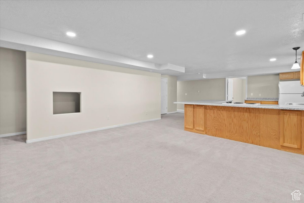 Kitchen with open floor plan, white appliances, light countertops, recessed lighting, and light colored carpet
