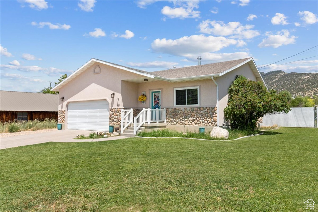 Ranch-style house featuring stone siding, stucco siding, an attached garage, and driveway