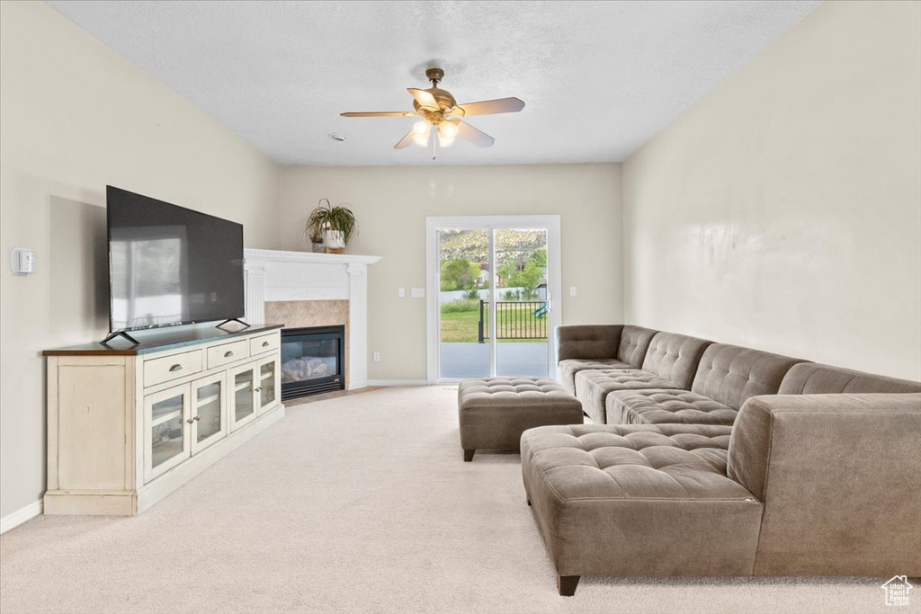 Living area featuring a ceiling fan, carpet flooring, and a high end fireplace
