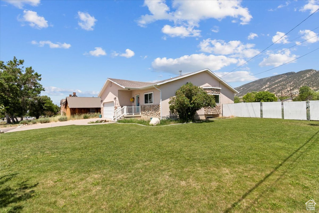 View of front of property with concrete driveway, an attached garage, a mountain view, and stucco siding