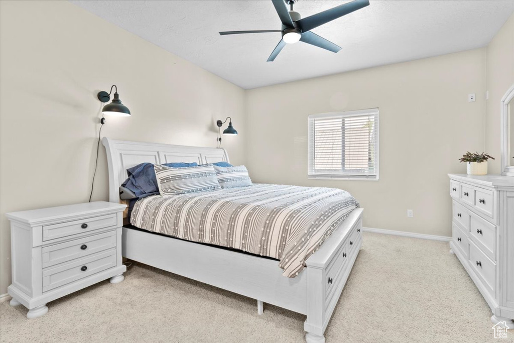 Bedroom with light colored carpet and a ceiling fan