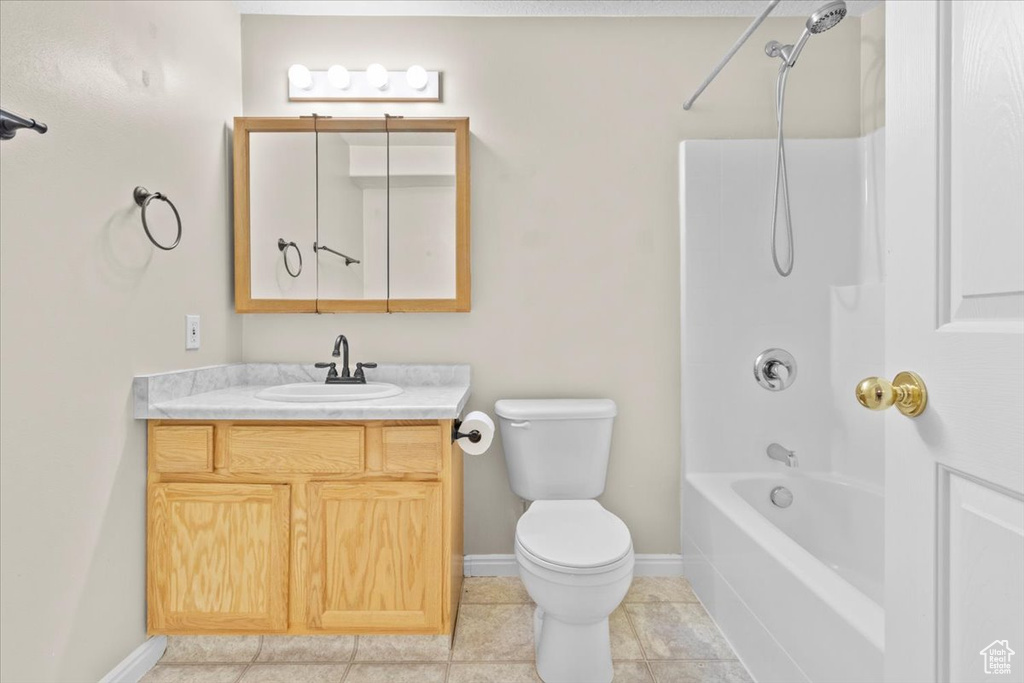 Bathroom featuring vanity, bathtub / shower combination, and tile patterned floors