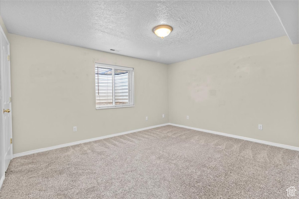Empty room with a textured ceiling and carpet