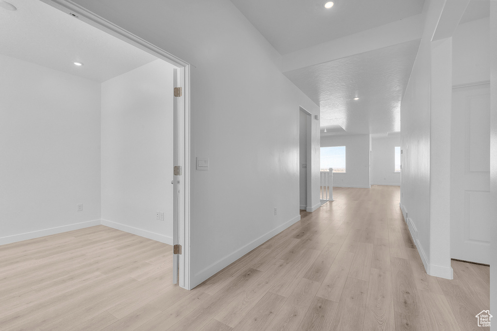 Corridor featuring light wood-style flooring and recessed lighting
