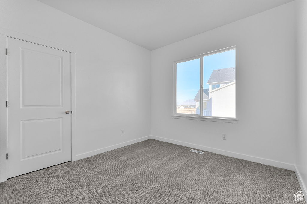 Carpeted empty room featuring baseboards