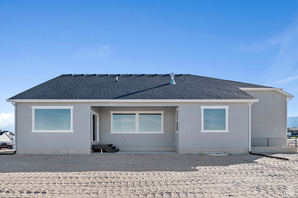 Back of property with roof with shingles
