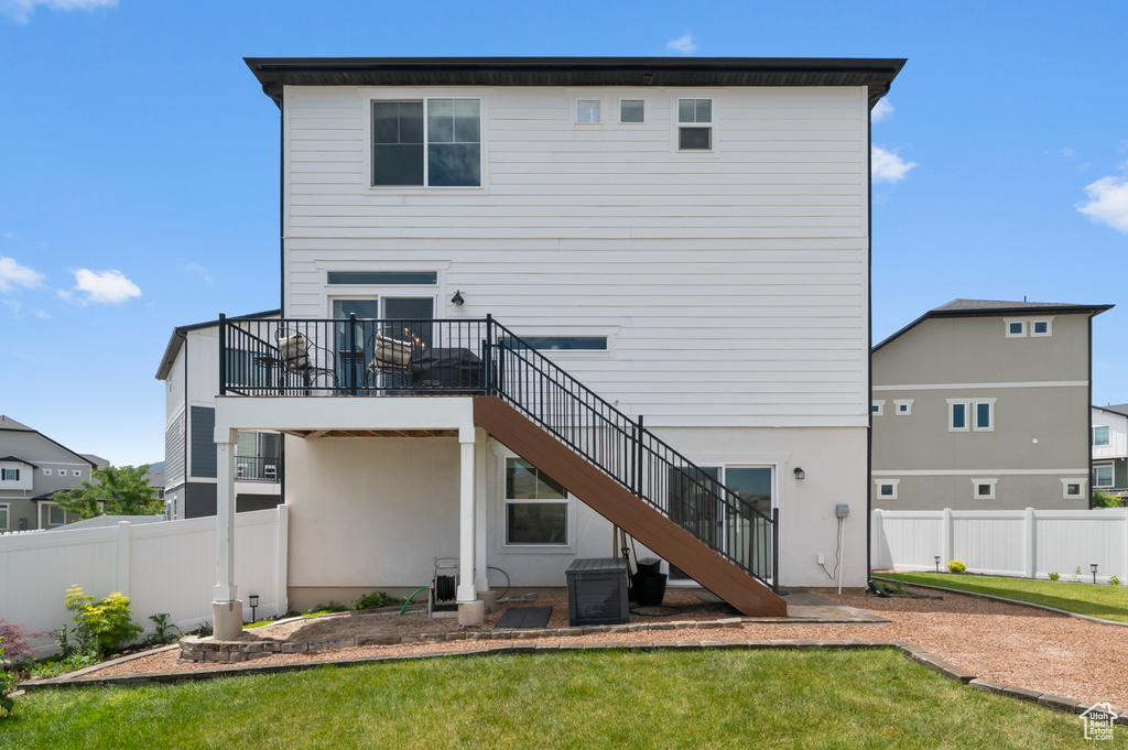 Rear view of house featuring stairway and a fenced backyard