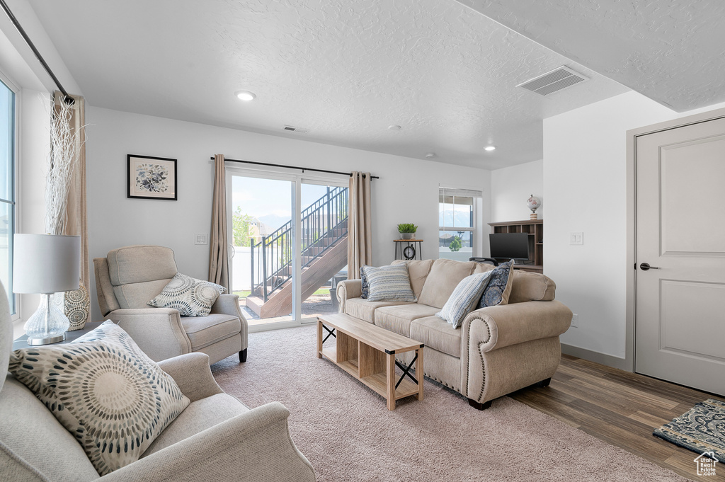 Living area featuring recessed lighting, a textured ceiling, and wood finished floors
