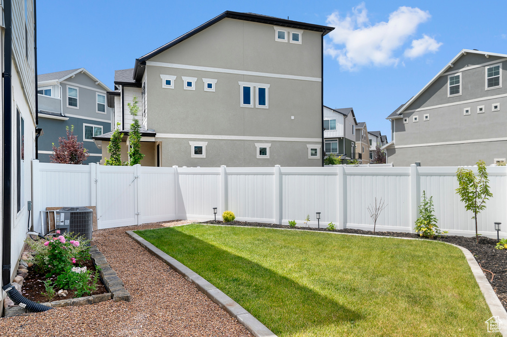 Fenced backyard featuring a residential view and a gate