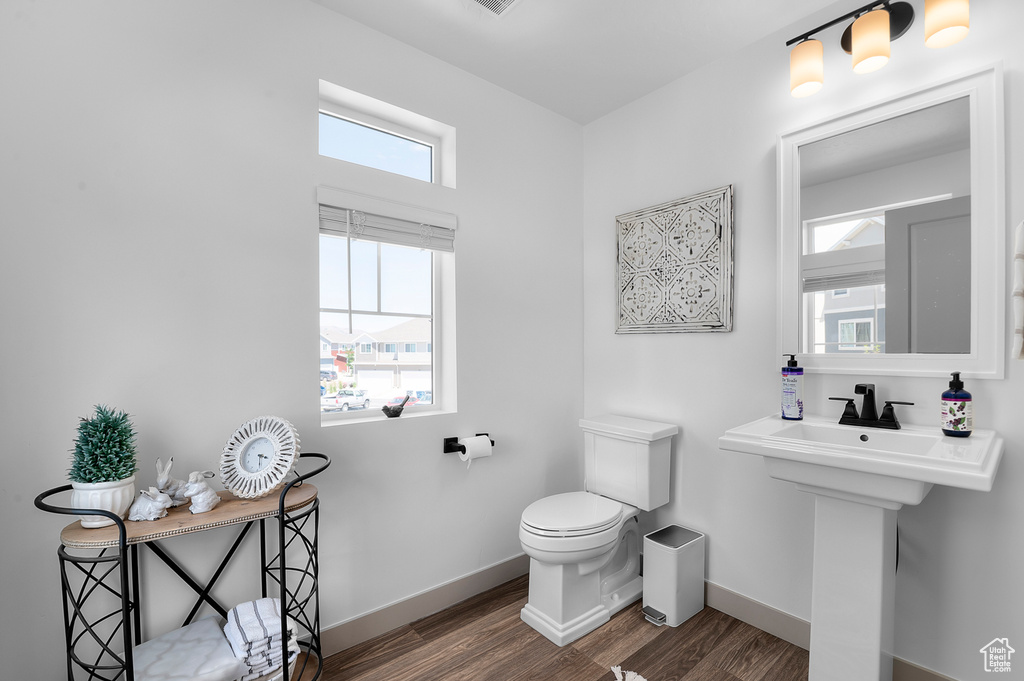Half bath featuring toilet and wood finished floors