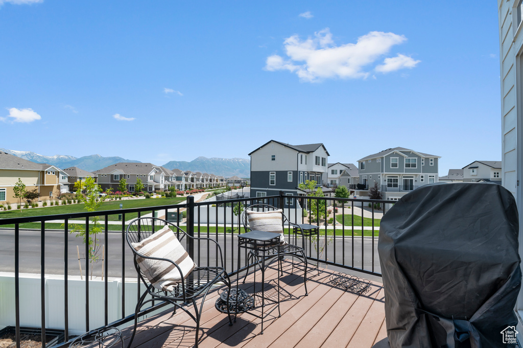 Wooden deck with a residential view, a mountain view, and grilling area