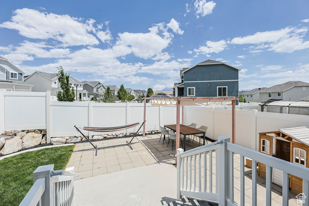 Fenced backyard featuring a residential view, outdoor dining space, and a patio area