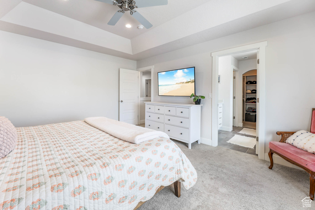 Bedroom featuring light carpet, recessed lighting, a ceiling fan, a tray ceiling, and arched walkways
