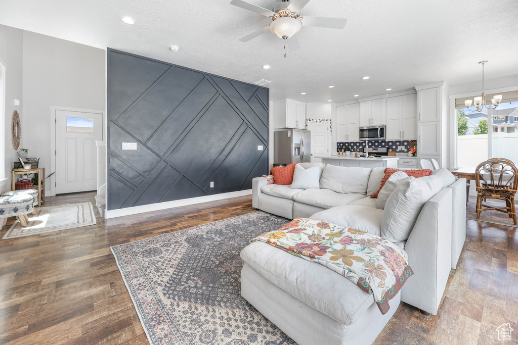 Living area with a chandelier, a ceiling fan, recessed lighting, and wood finished floors