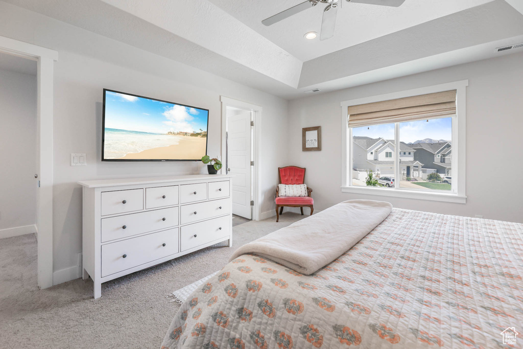 Bedroom featuring light colored carpet, recessed lighting, a ceiling fan, and a raised ceiling