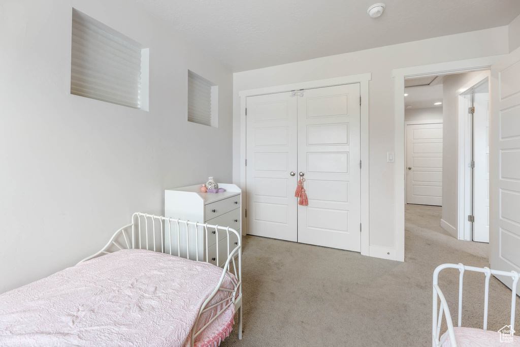 Bedroom featuring light colored carpet and a closet