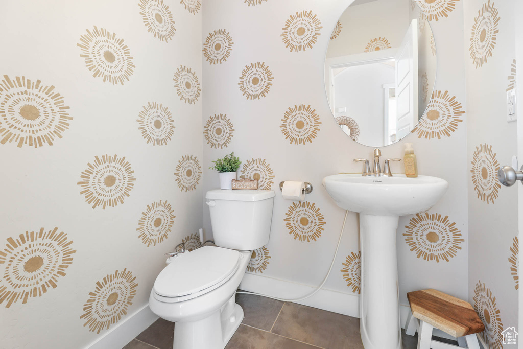 Half bathroom featuring tile patterned flooring and toilet