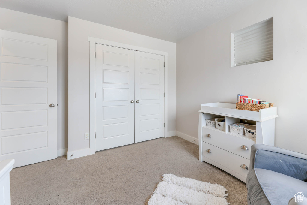 Living area featuring light carpet and baseboards