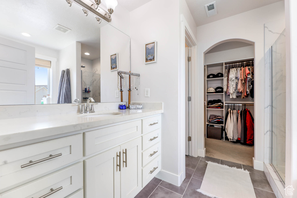 Full bathroom featuring vanity, a stall shower, a spacious closet, tile patterned flooring, and recessed lighting