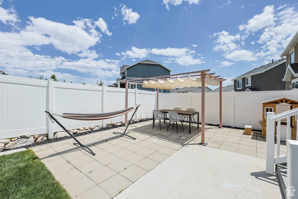Fenced backyard featuring a pergola, a patio, and outdoor dining area