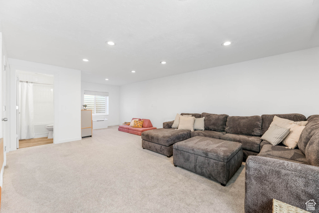 Living area with light colored carpet and recessed lighting