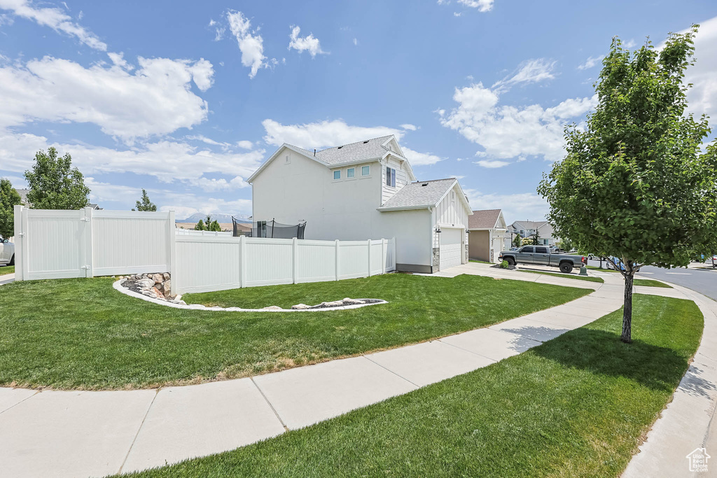 View of property exterior with driveway, an attached garage, and roof with shingles