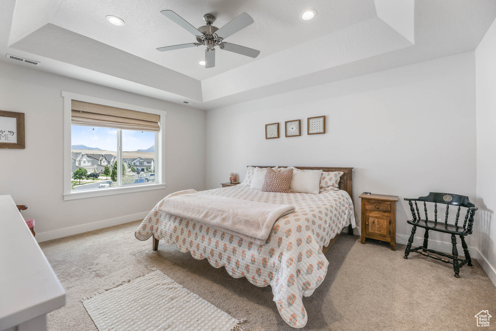 Bedroom with carpet flooring, a raised ceiling, recessed lighting, and a ceiling fan