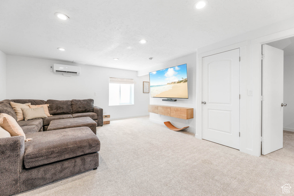 Carpeted living area featuring a wall mounted AC and recessed lighting