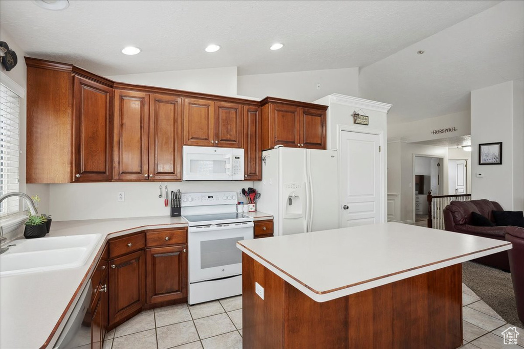 Kitchen with white appliances, light tile patterned flooring, lofted ceiling, light countertops, and open floor plan
