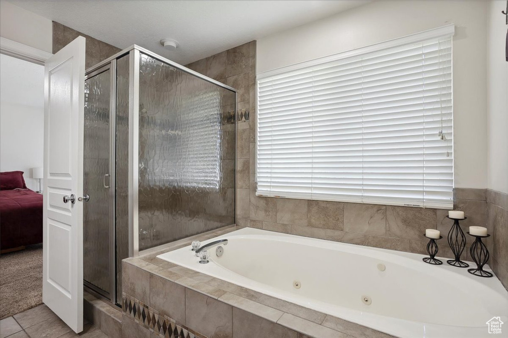 Ensuite bathroom with a tub with jets, a stall shower, and tile patterned flooring