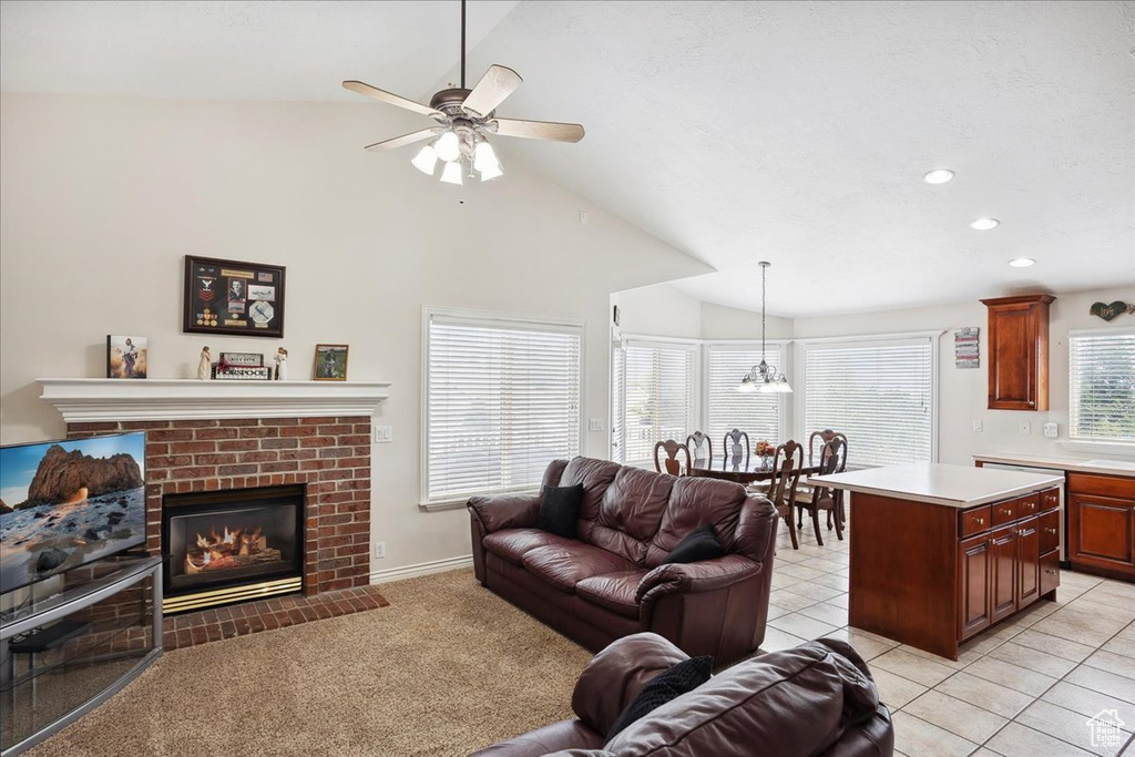 Living room featuring lofted ceiling, a ceiling fan, a brick fireplace, and recessed lighting