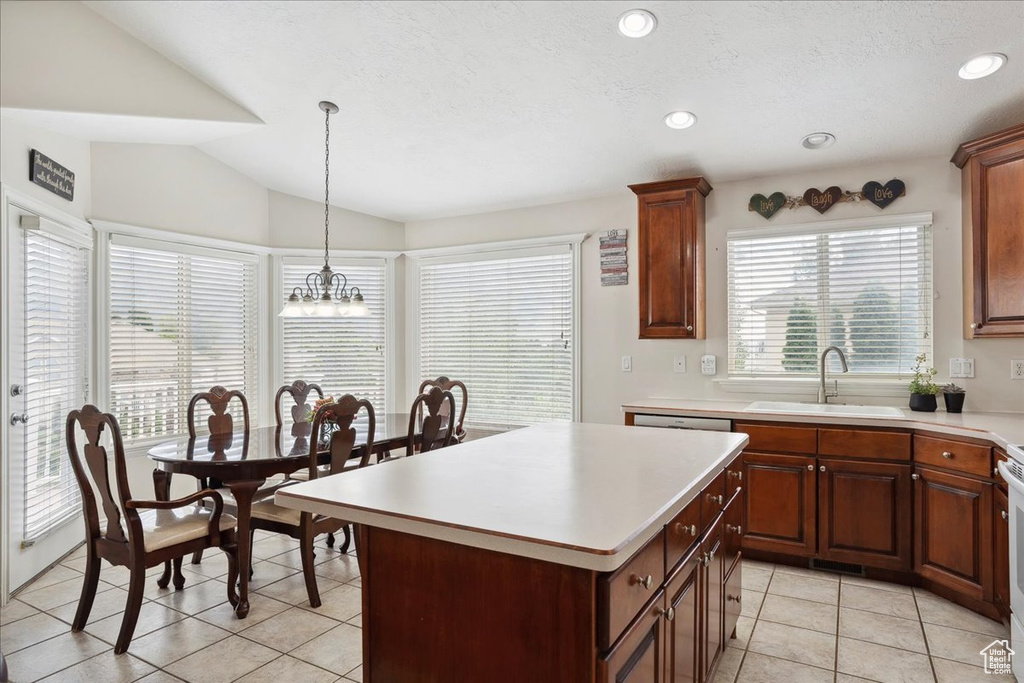 Kitchen featuring light tile patterned floors, light countertops, a chandelier, a center island, and lofted ceiling