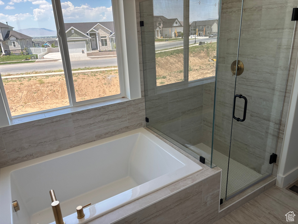Bathroom featuring a bath, a shower stall, and a residential view