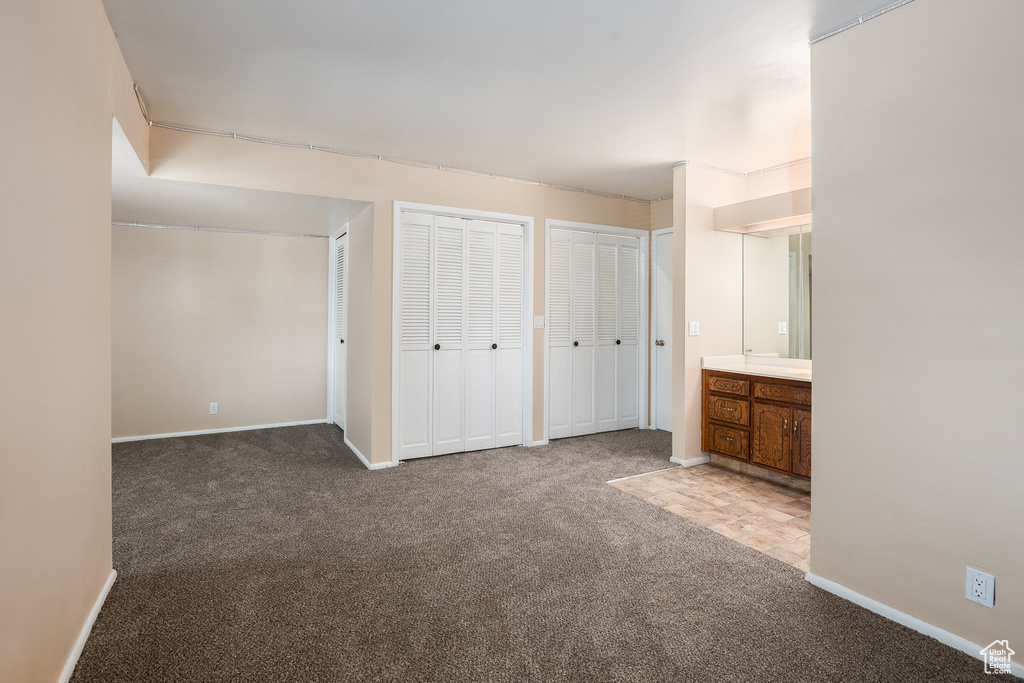 Unfurnished bedroom with carpet and two closets
