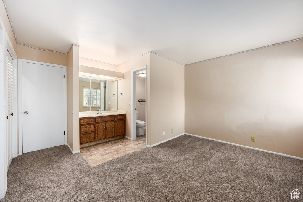 Unfurnished bedroom featuring carpet flooring and ensuite bathroom