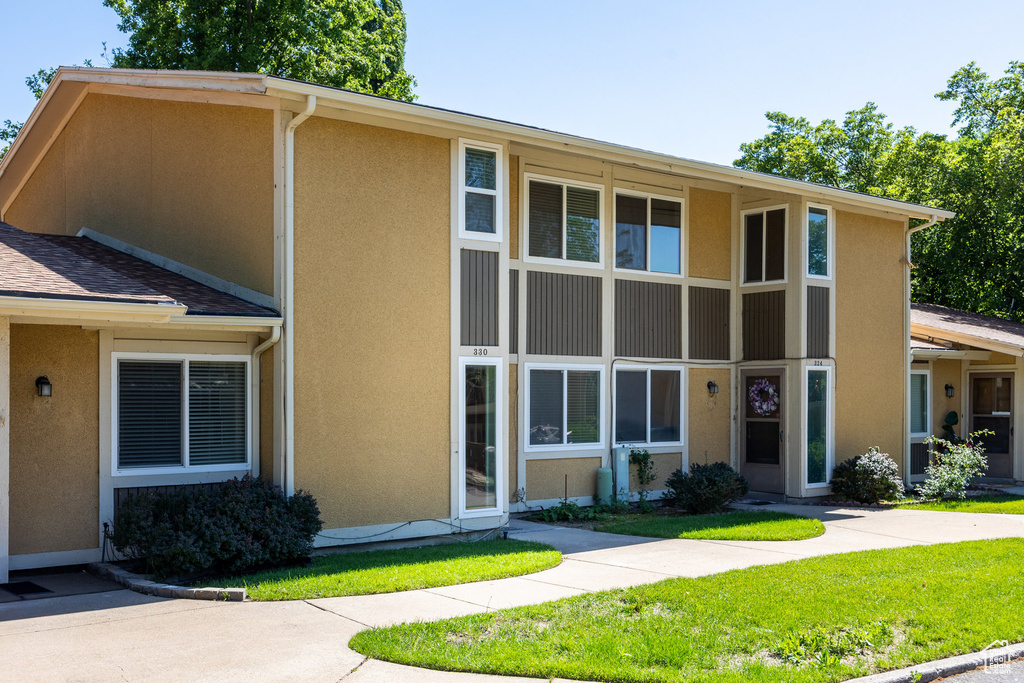 View of front of home with stucco siding and a front lawn