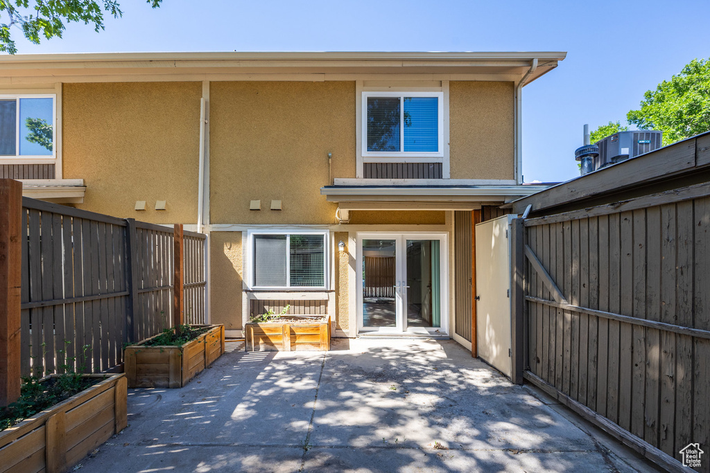 Rear view of house with stucco siding, a patio, and french doors
