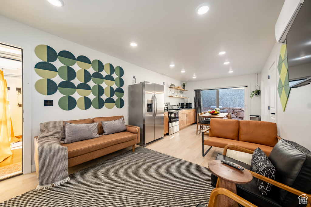Living area with light wood-style flooring and recessed lighting
