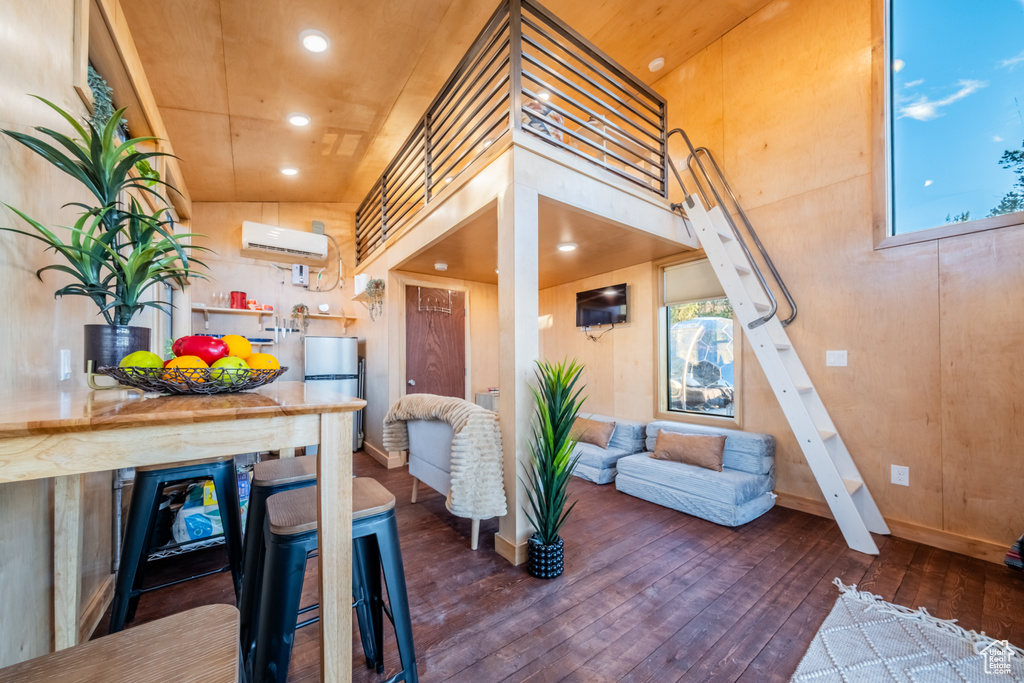 Kitchen with a wall unit AC, hardwood / wood-style floors, freestanding refrigerator, and recessed lighting