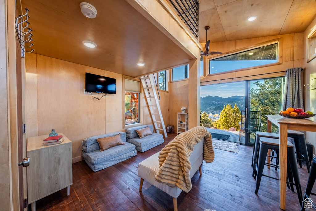 Living room featuring hardwood / wood-style floors, recessed lighting, and wooden walls