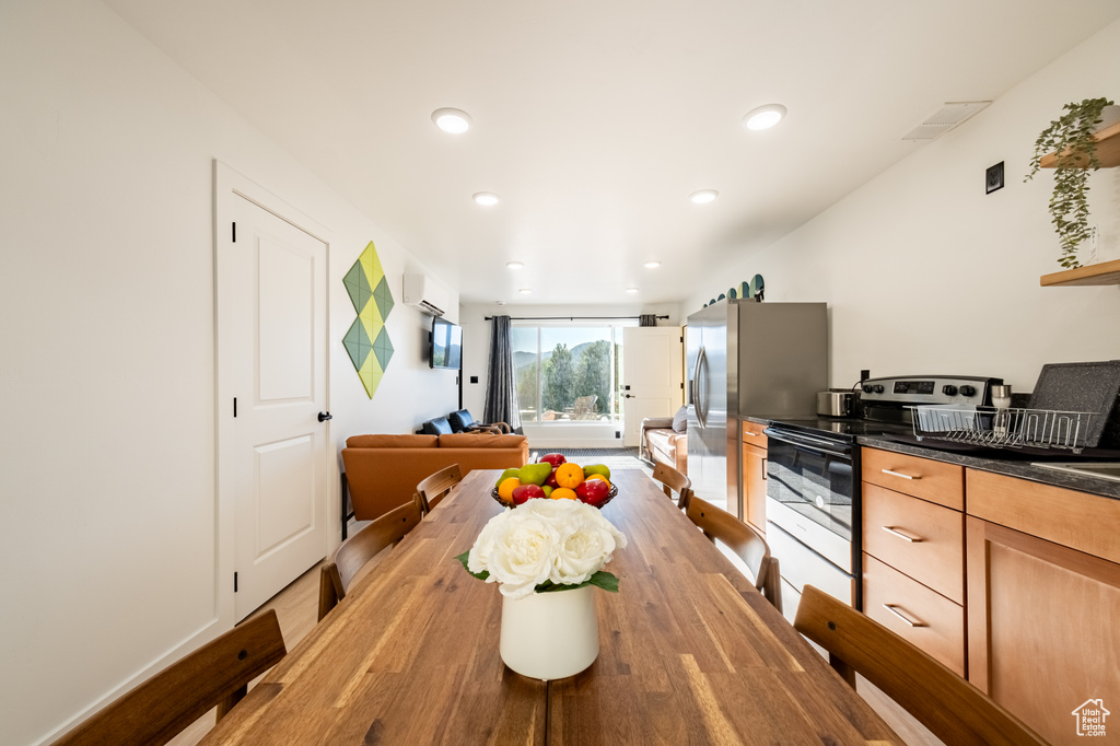 Dining room featuring an AC wall unit, recessed lighting, and light wood finished floors