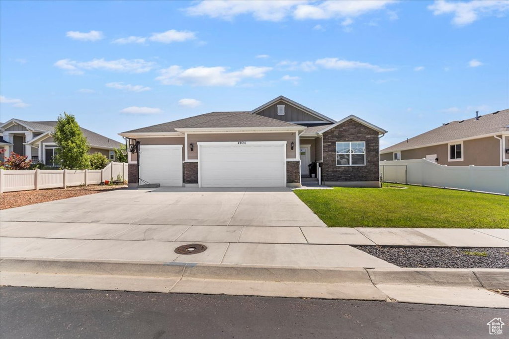 View of front of property featuring an attached garage, concrete driveway, and brick siding