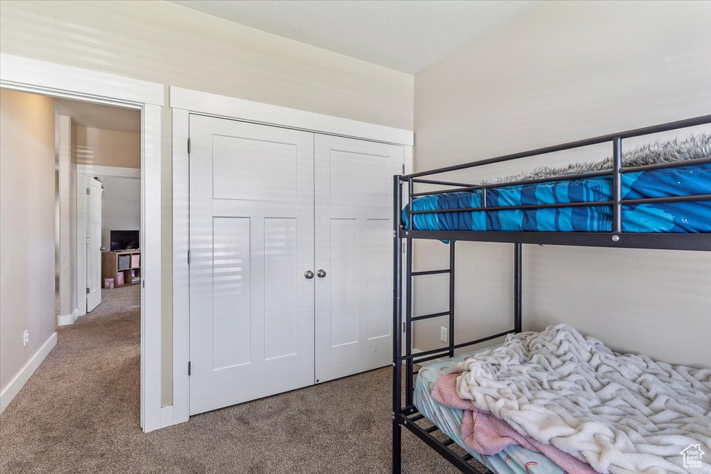 Bedroom featuring carpet flooring and a closet