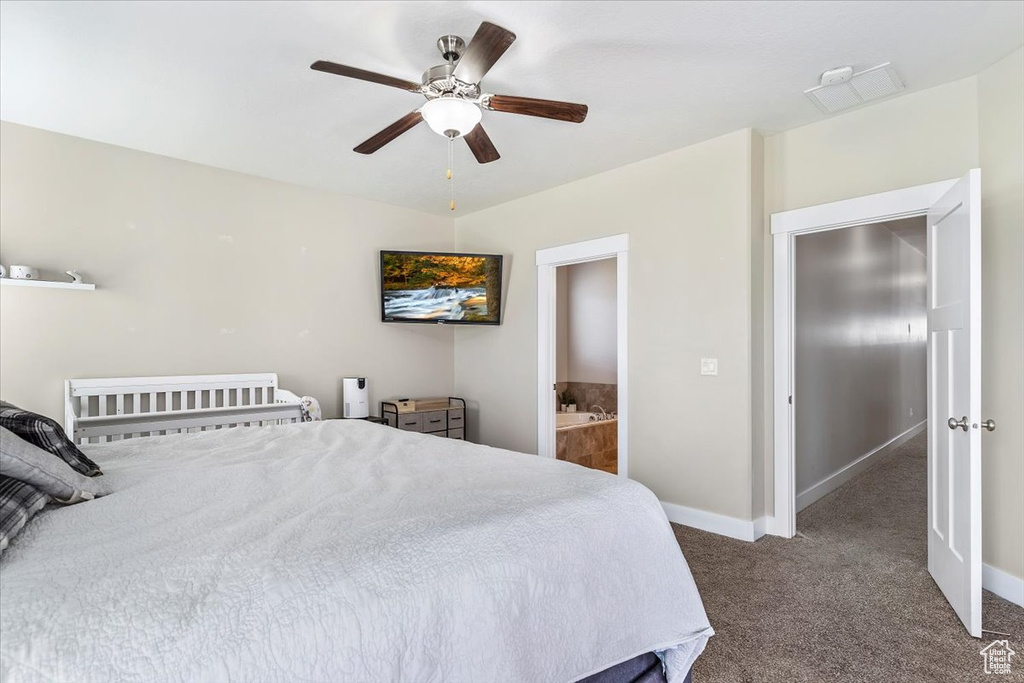 Bedroom with carpet, ensuite bathroom, and a ceiling fan